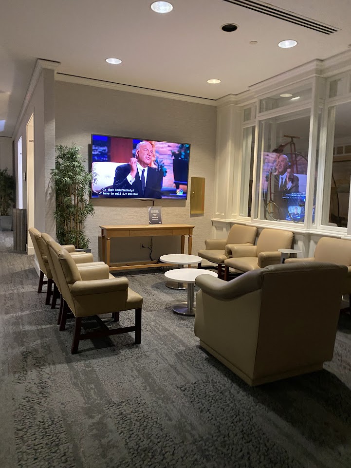 Seating around a television in the Delta Sky Club in Orlando