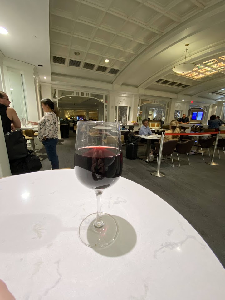 Table with a glass of wine in the dining area of the Delta Sky Club in Orlando