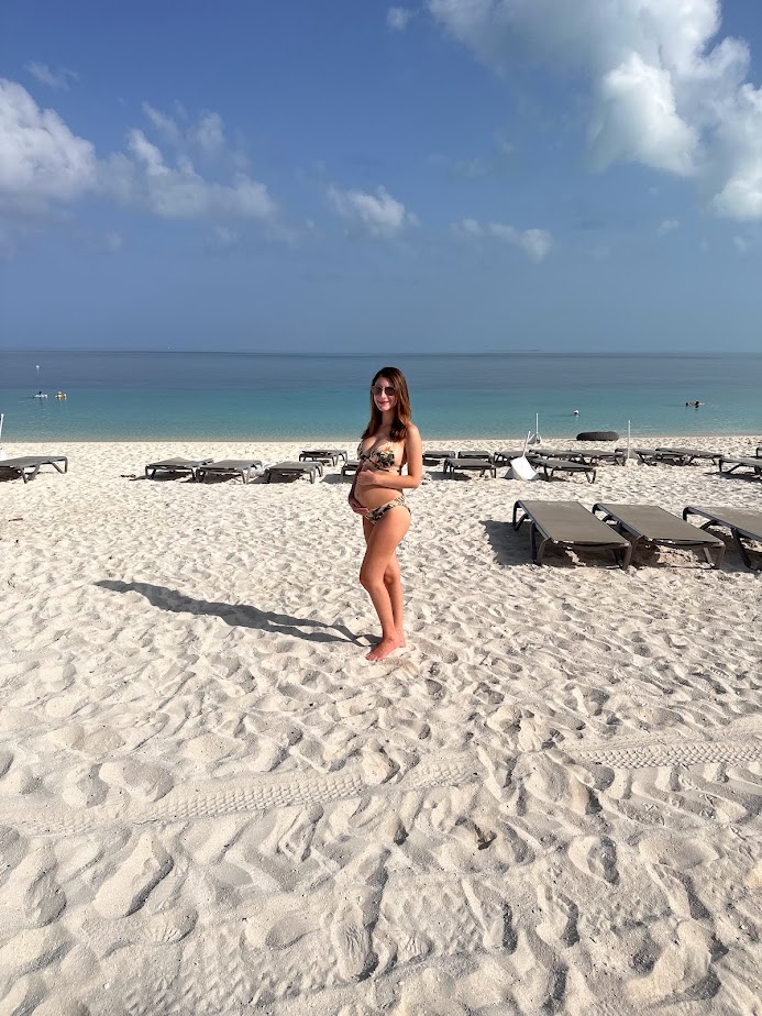 A picture of me pregnant on the beach in the Bahamas, a great summer babymoon destination.