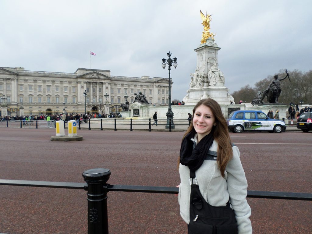 Julia standing in front of Buckingham Palace, which is one of the most popular places to visit in London. 