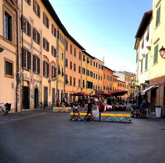 Picture of a street in Pisa that has a lot of shopping and restaurants